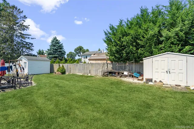 a view of a backyard with table and chairs and a large tree