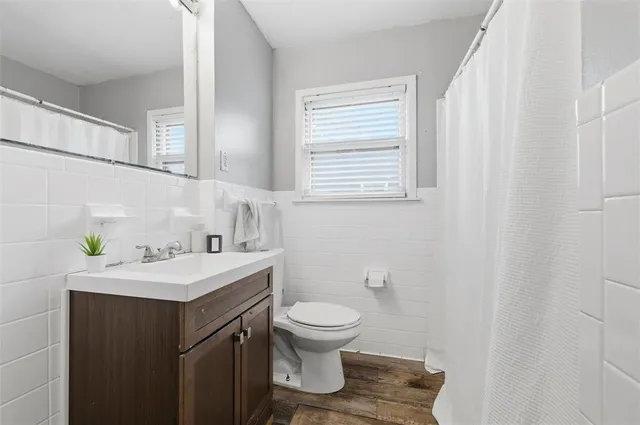 a bathroom with a sink a toilet and a window
