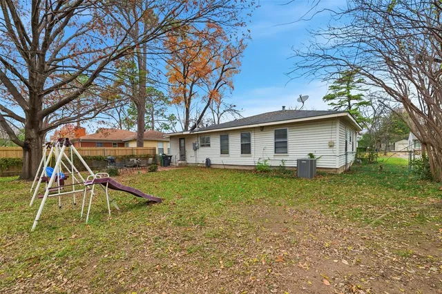 a view of a house with a yard chairs and a table