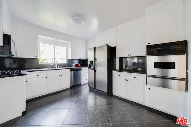 a kitchen with stainless steel appliances a refrigerator sink and cabinets