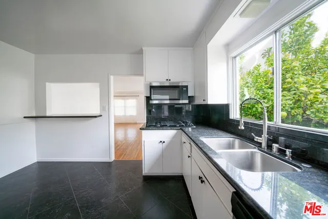 a kitchen with granite countertop a sink and a stove top oven