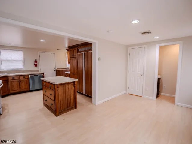 a view of kitchen with stainless steel appliances granite countertop a sink and a refrigerator
