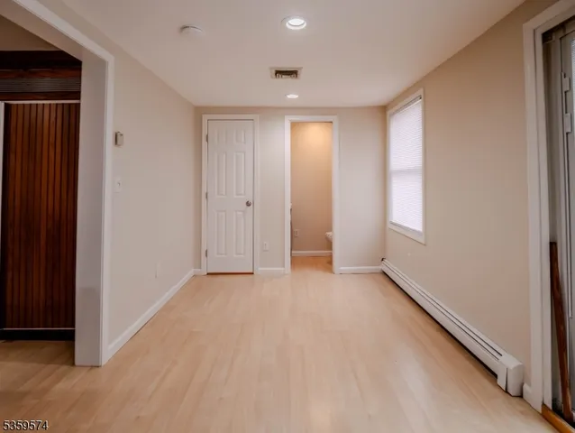 a view of an empty room with wooden floor