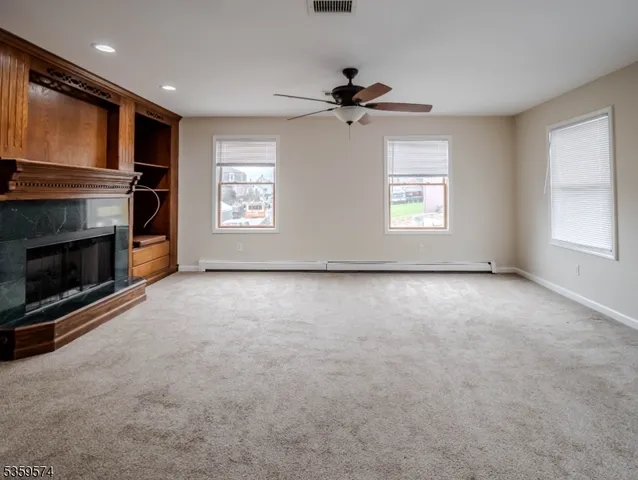 a view of a livingroom with wooden floor and a ceiling fan