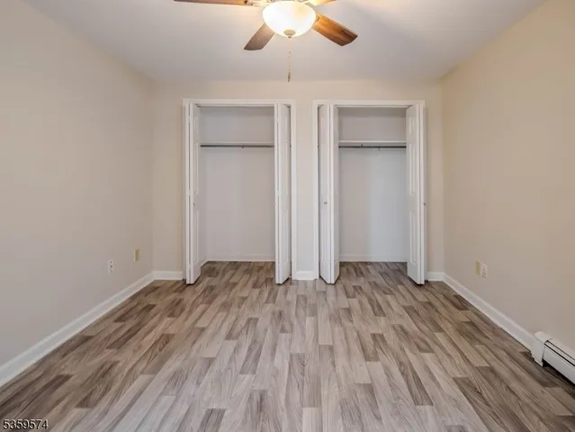 an empty room with windows and fan