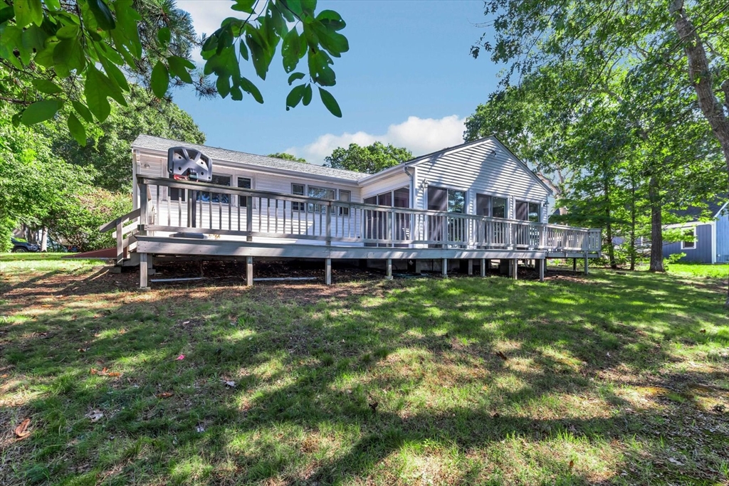 9 Point Road Mashpee, MA 02649 - Photo 6 of 27 a view of a house with a deck and a yard