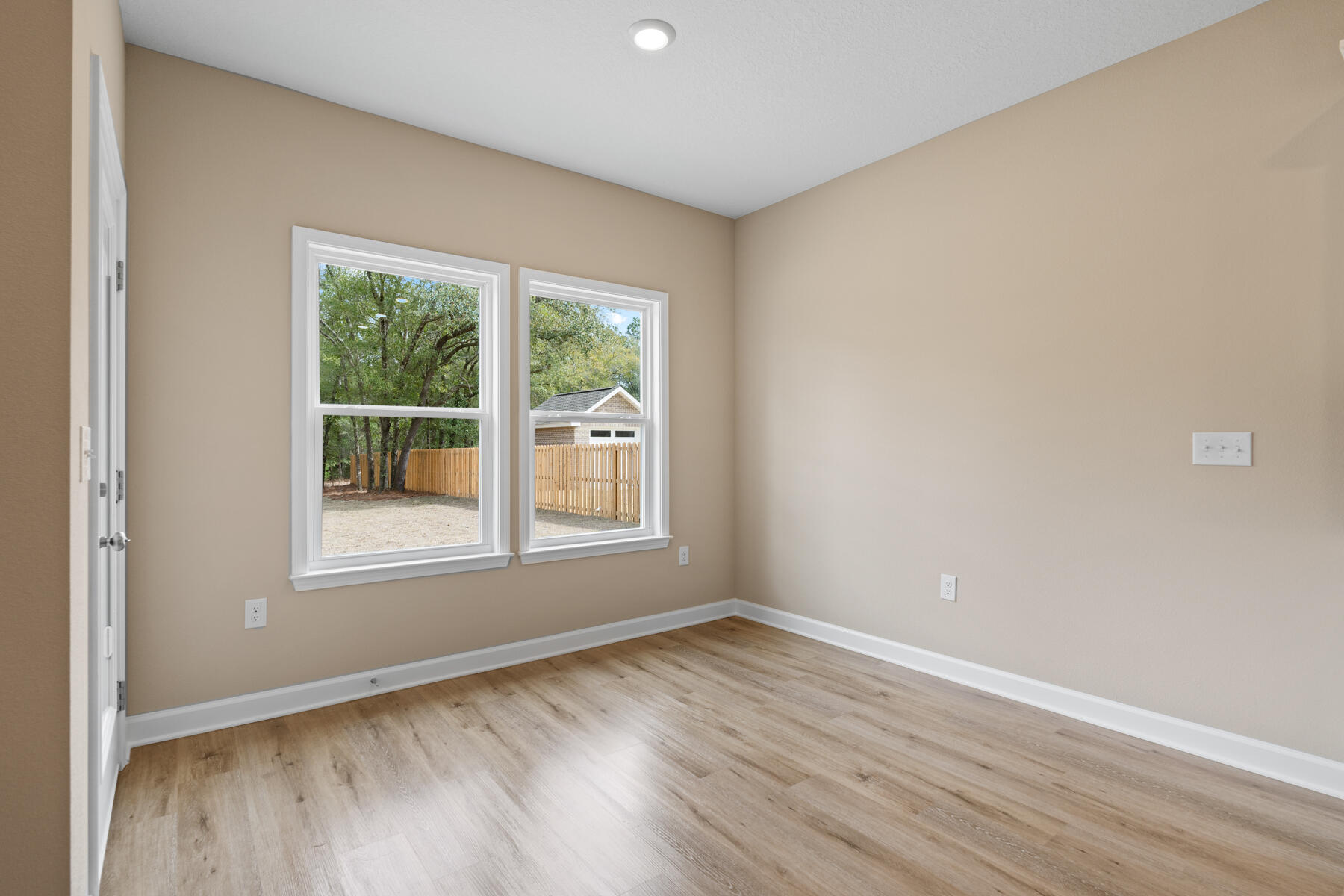 6011 Sand Hill Road Crestview, FL 32539 - Photo 10 of 16 an empty room with wooden floor and windows