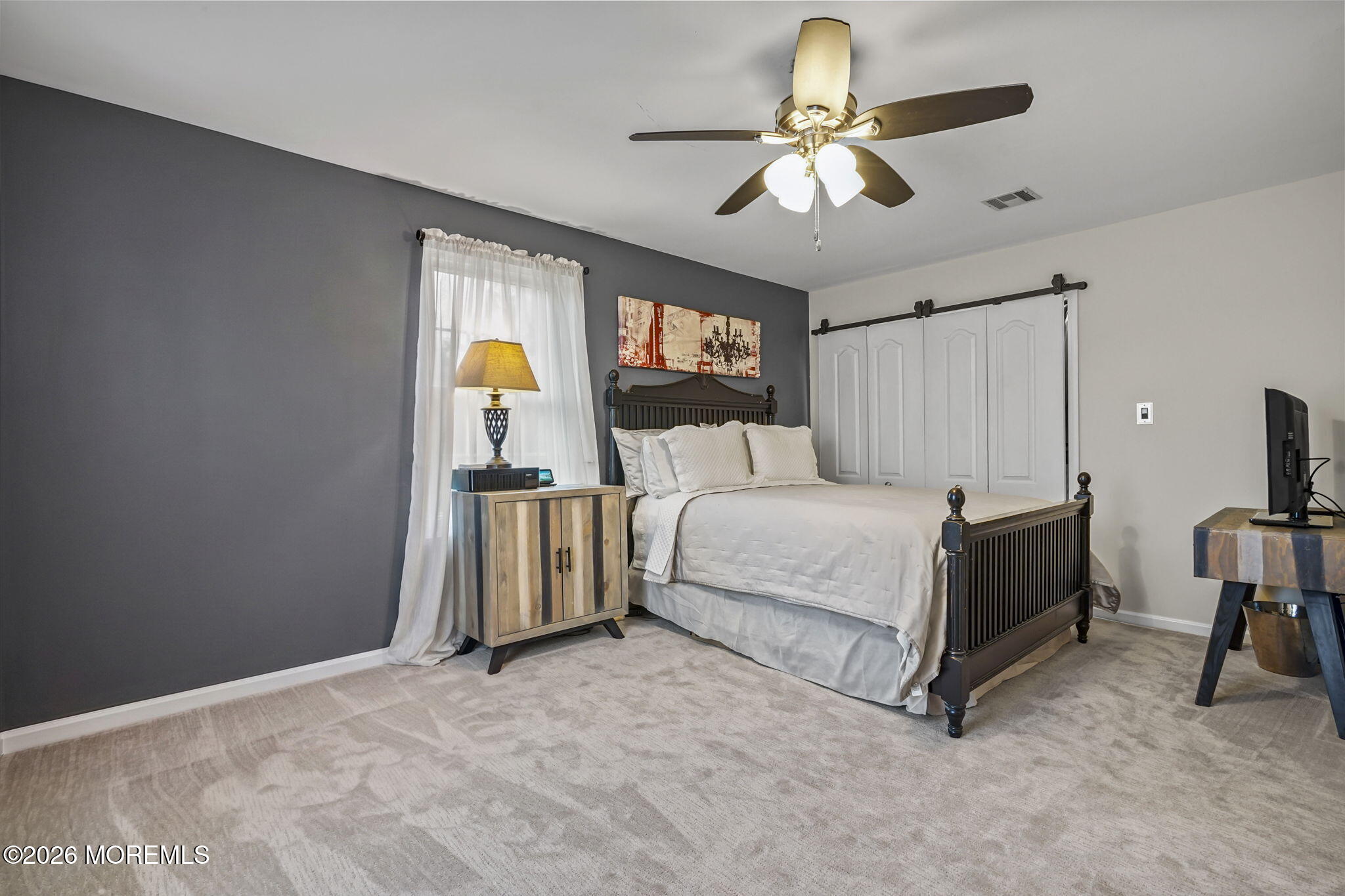 438 Bennetts Mills Road Jackson, NJ 08527 - Photo 21 of 42 a bedroom with a bed and a chandelier