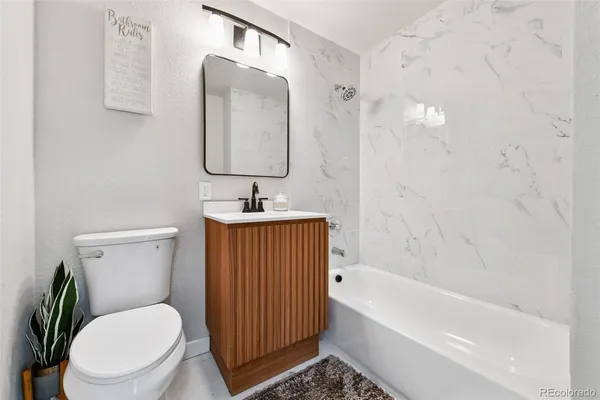 a bathroom with a toilet a sink and bathtub