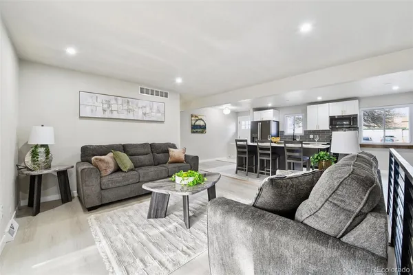 a living room with furniture and kitchen view