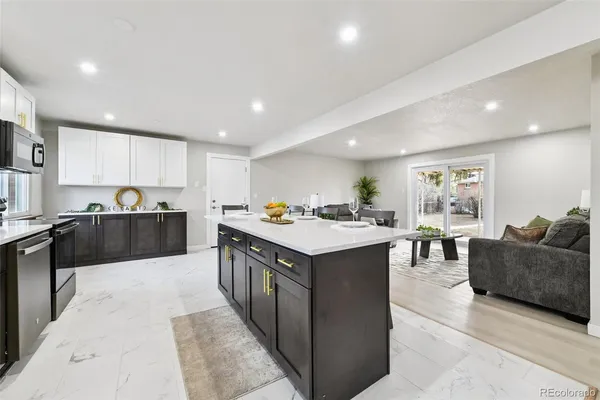 a large kitchen with stainless steel appliances kitchen island granite countertop a large counter top and a stove top oven