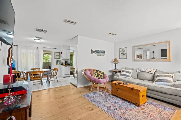 a living room with furniture a rug and a dining table