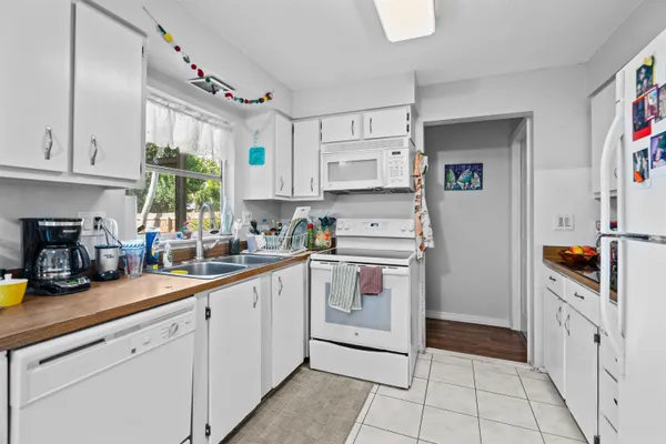 a kitchen with white cabinets and white appliances