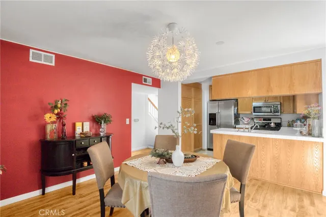 a dining room with furniture a chandelier and wooden floor