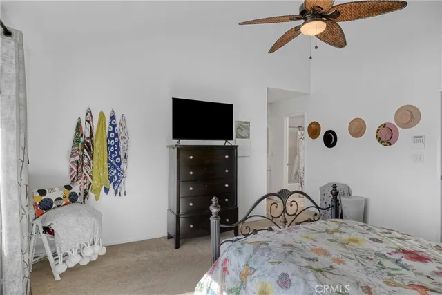 a bedroom with a bed and a flat tv screen on dresser