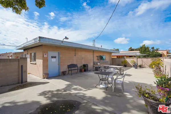 a view of a patio with table and chairs potted plants