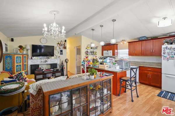 a view of a dining room with furniture a kitchen and chandelier