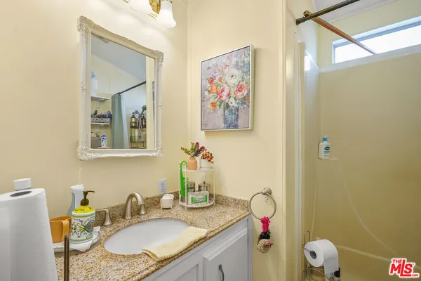 a bathroom with a granite countertop sink mirror vanity and toilet