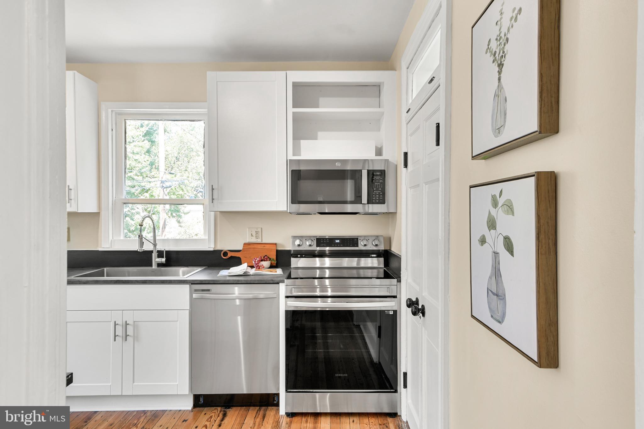 23 West 4th Street Frederick, MD 21701 - Photo 68 of 105 a kitchen with stainless steel appliances granite countertop a stove a sink and a microwave