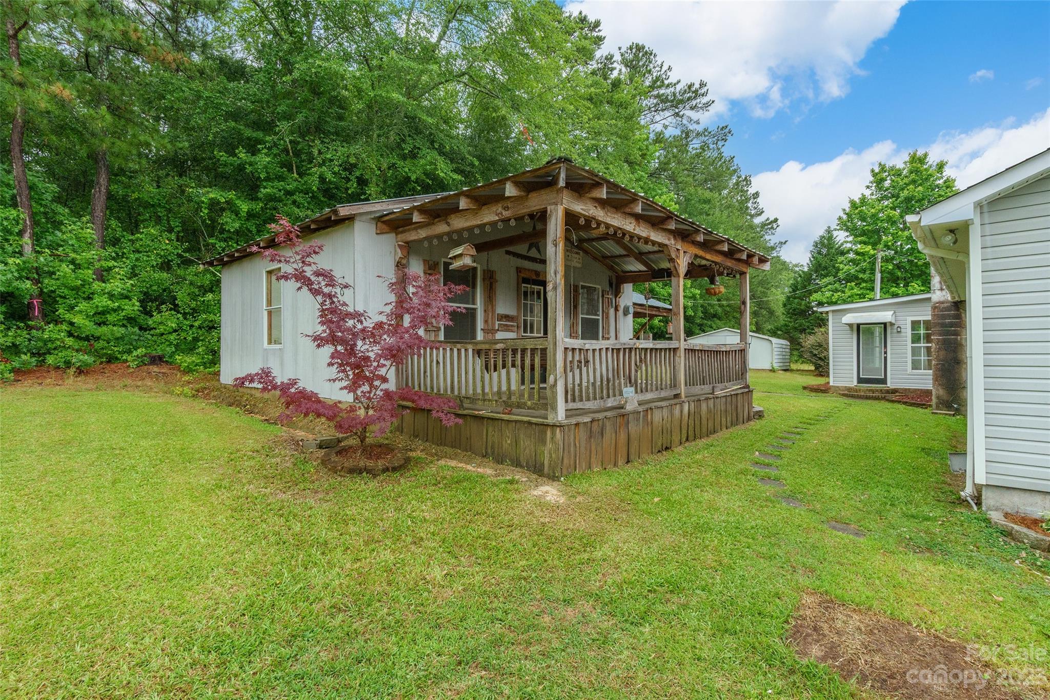 74 Joe Miller Road Jefferson, SC 29718 - Photo 23 of 29 a view of a small house with a big yard and large trees