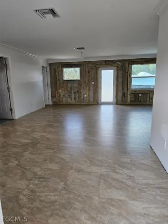 an empty room with window and wooden floor