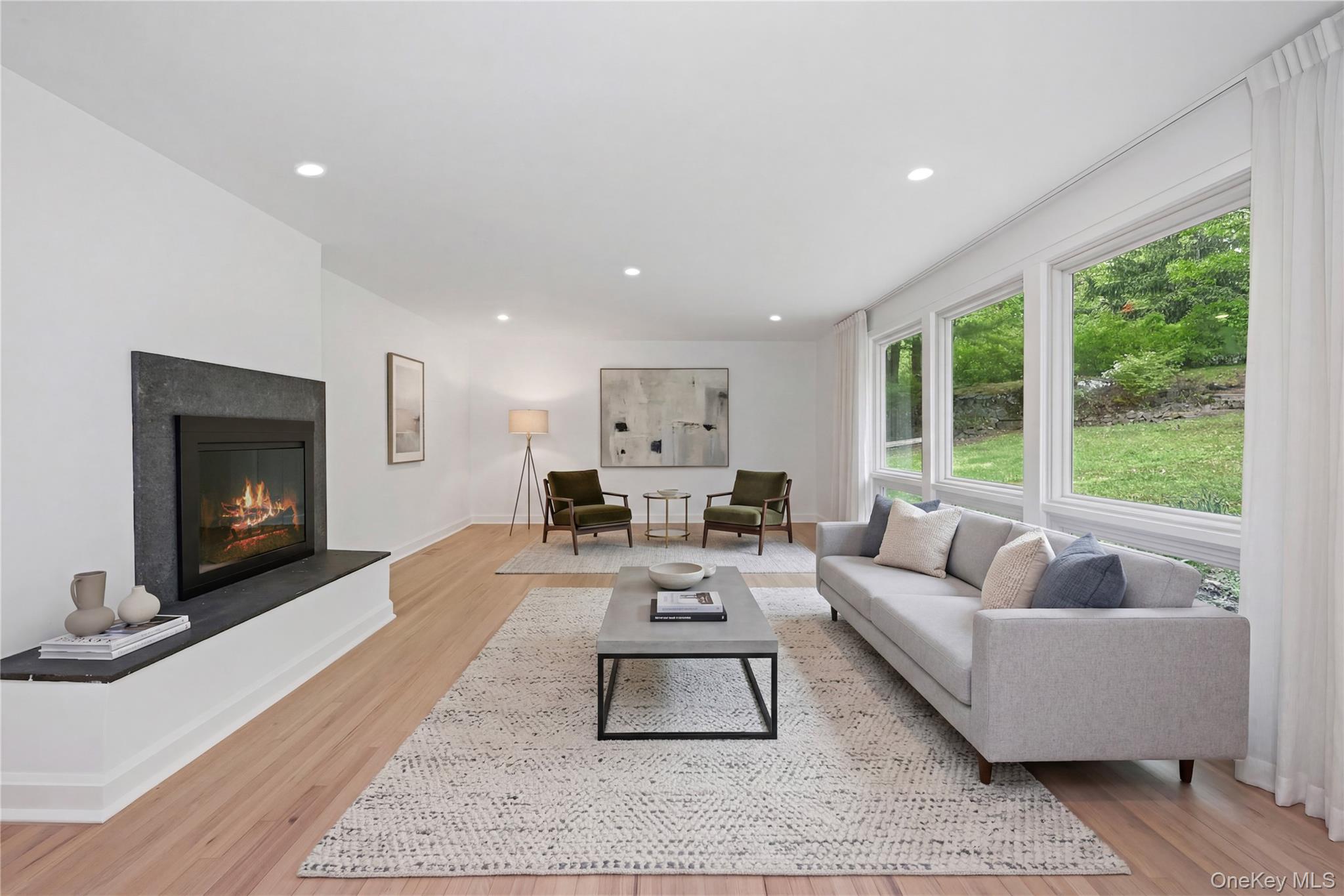24 Country Road Mamaroneck, NY 10543 - Photo 3 of 37 a living room with furniture a large window and a fireplace