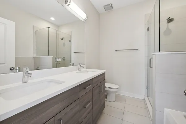 a bathroom with a double vanity sink toilet and a mirror