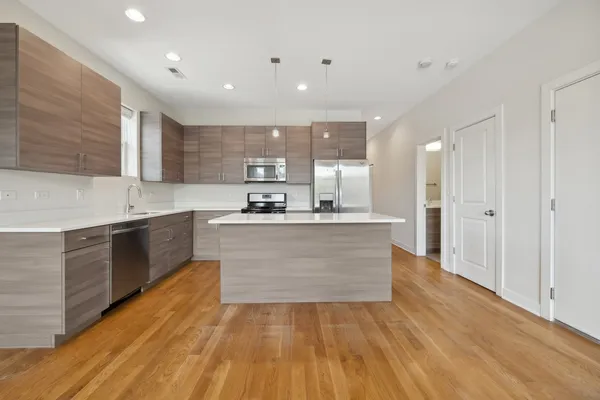 a large kitchen with kitchen island a sink stainless steel appliances and cabinets