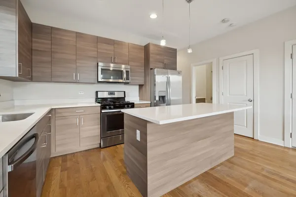 a kitchen with kitchen island granite countertop a stove and a sink