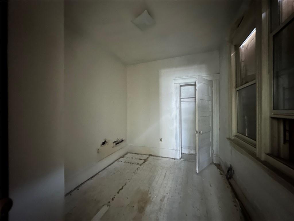 702 Whitney Avenue Pittsburgh, PA 15221 - Photo 8 of 39 an empty room with wooden floor and a bathroom