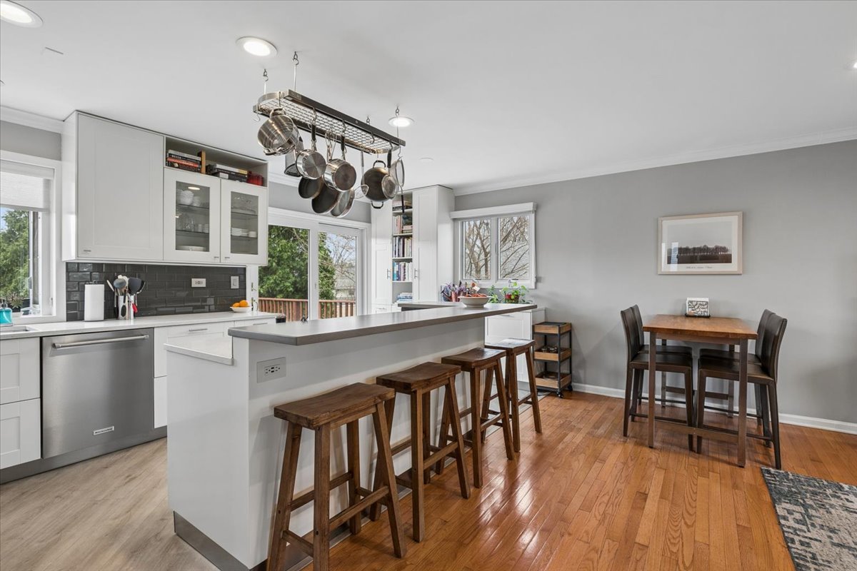 904 West Woodland Road Lake Bluff, IL 60044 - Photo 4 of 28 a kitchen with stainless steel appliances granite countertop a stove a sink a dining table and chairs