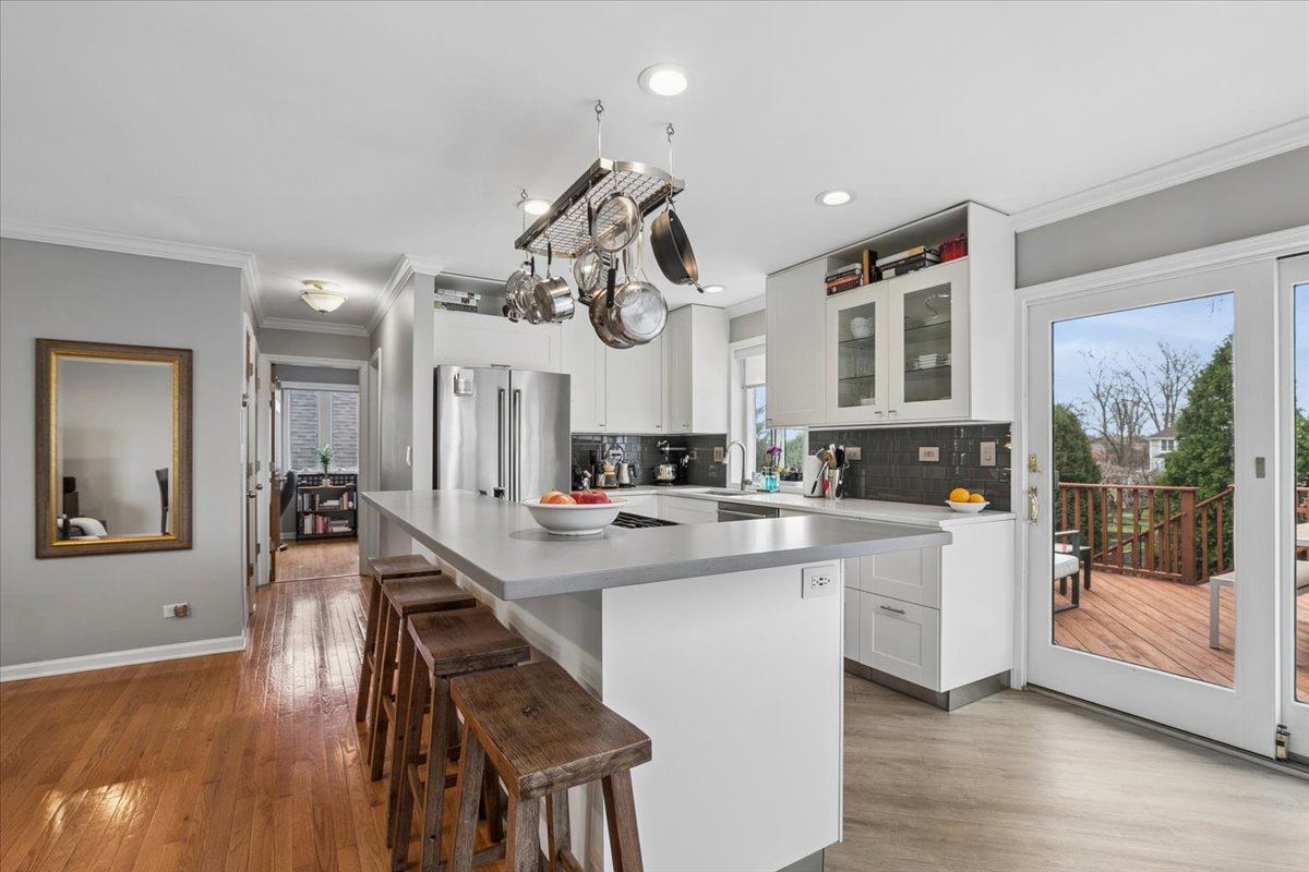 904 West Woodland Road Lake Bluff, IL 60044 - Photo 6 of 28 a very nice looking open dining room with kitchen island furniture a large window and wooden floor