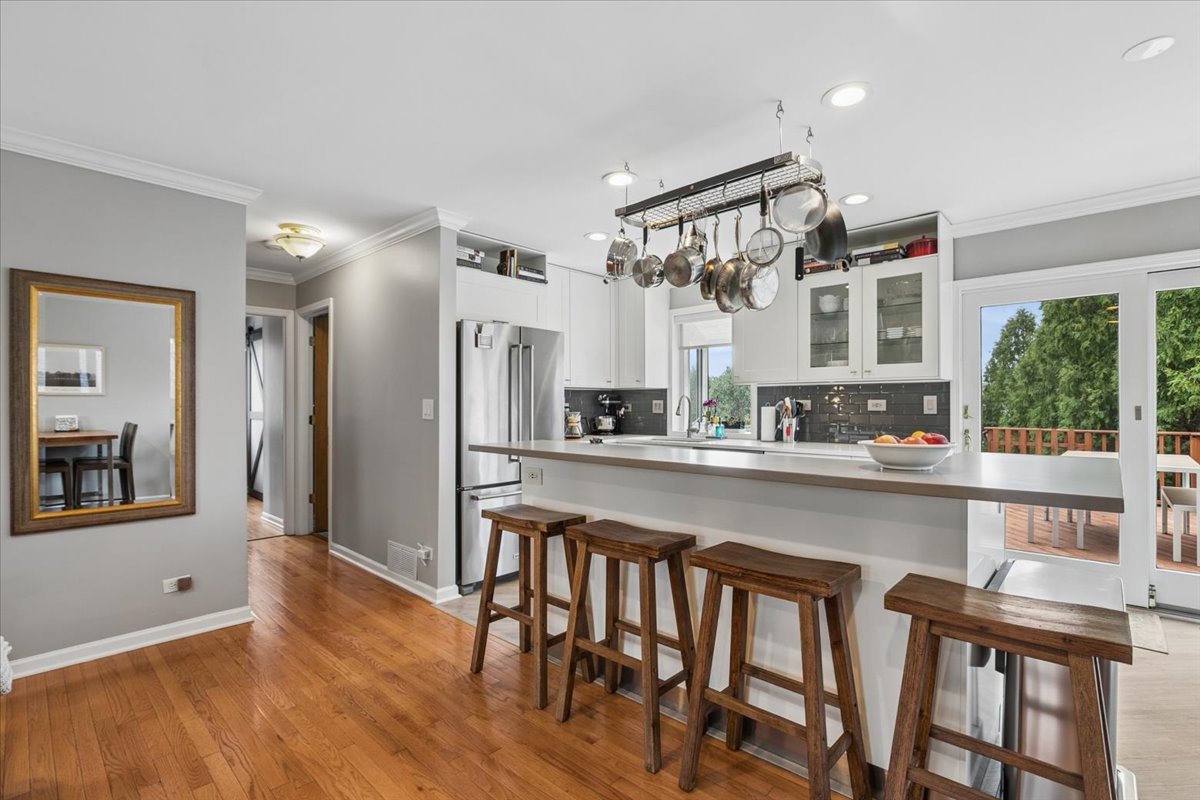 904 West Woodland Road Lake Bluff, IL 60044 - Photo 7 of 28 a kitchen with stainless steel appliances a dining table chairs and wooden floor