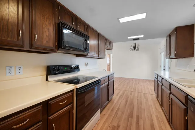 a kitchen with stainless steel appliances granite countertop wooden cabinets a stove top oven a sink and dishwasher