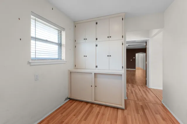 a view of a room with wooden floor and white doors