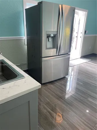 a kitchen with stainless steel appliances a stove a sink and a refrigerator