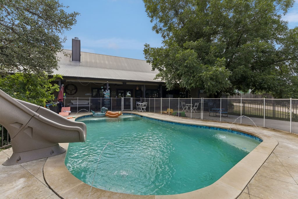 10111 Signal Hill Road Austin, TX 78737 - Photo 25 of 40 Mature trees shade a private backyard pool featuring water fountains and a pool slide.