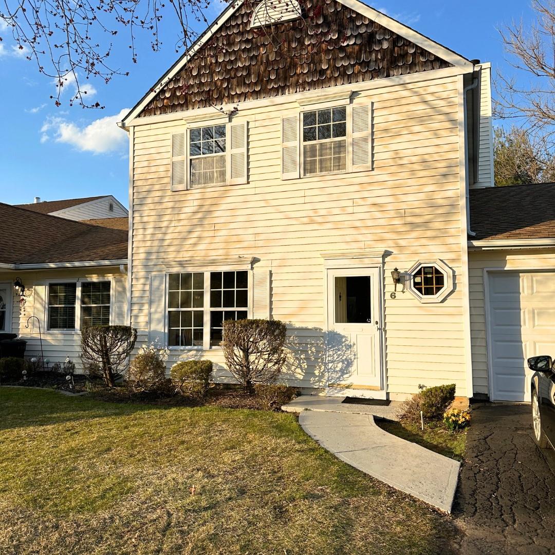 Rear view of house with an attached garage and a yard