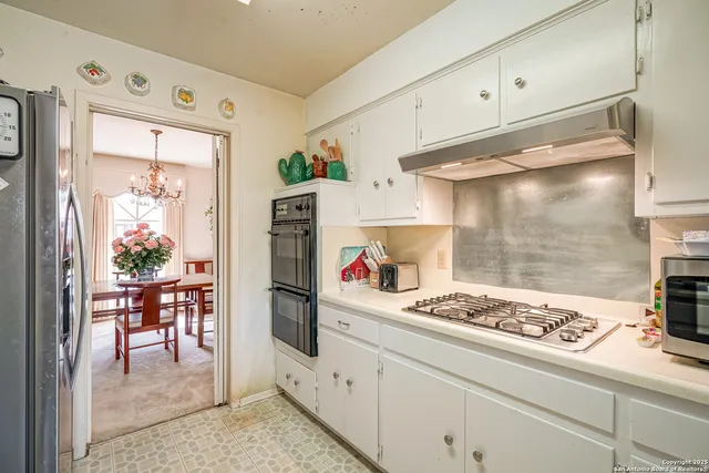 a kitchen with granite countertop a sink stove and refrigerator