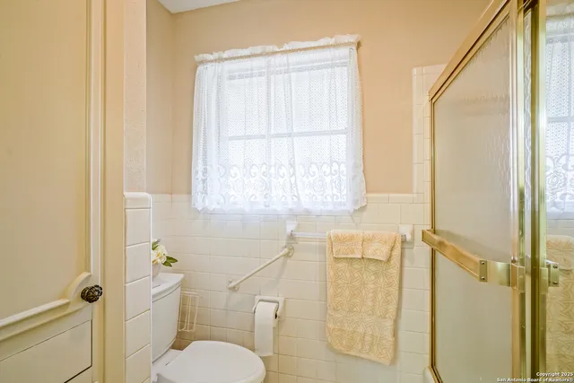 a bathroom with a toilet and a shower
