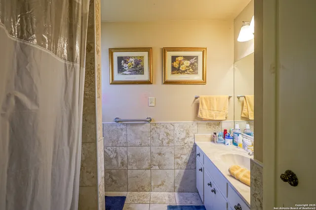 a bathroom with a tub sink and mirror