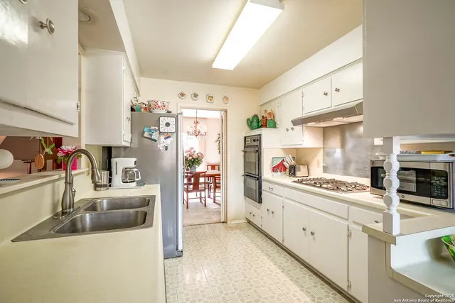 a kitchen with stainless steel appliances kitchen island granite countertop a refrigerator and a sink