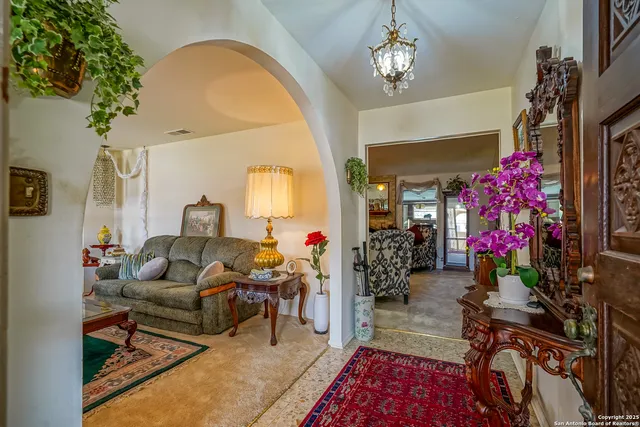 a living room with furniture and a chandelier