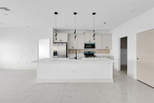 a large white kitchen with cabinets