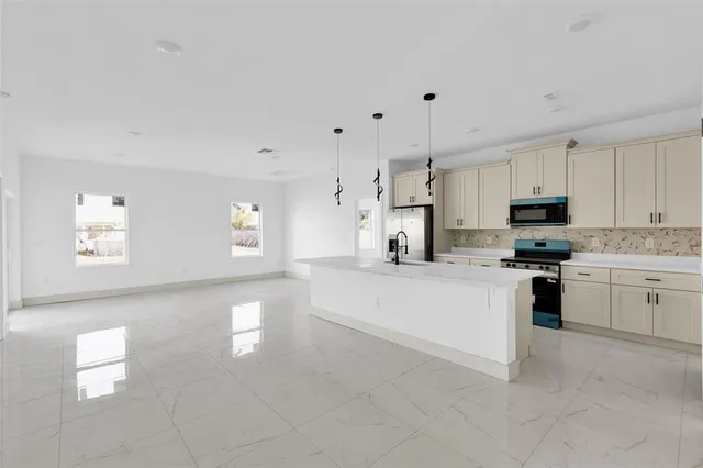 a large white kitchen with cabinets