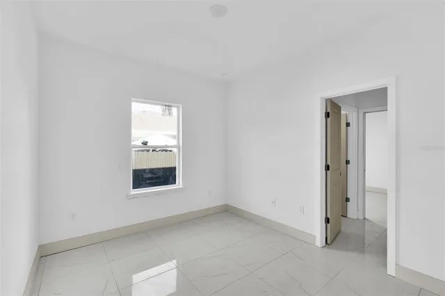 an empty room with a window and a ceiling fan