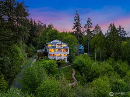 a front view of a house with a yard and tree s