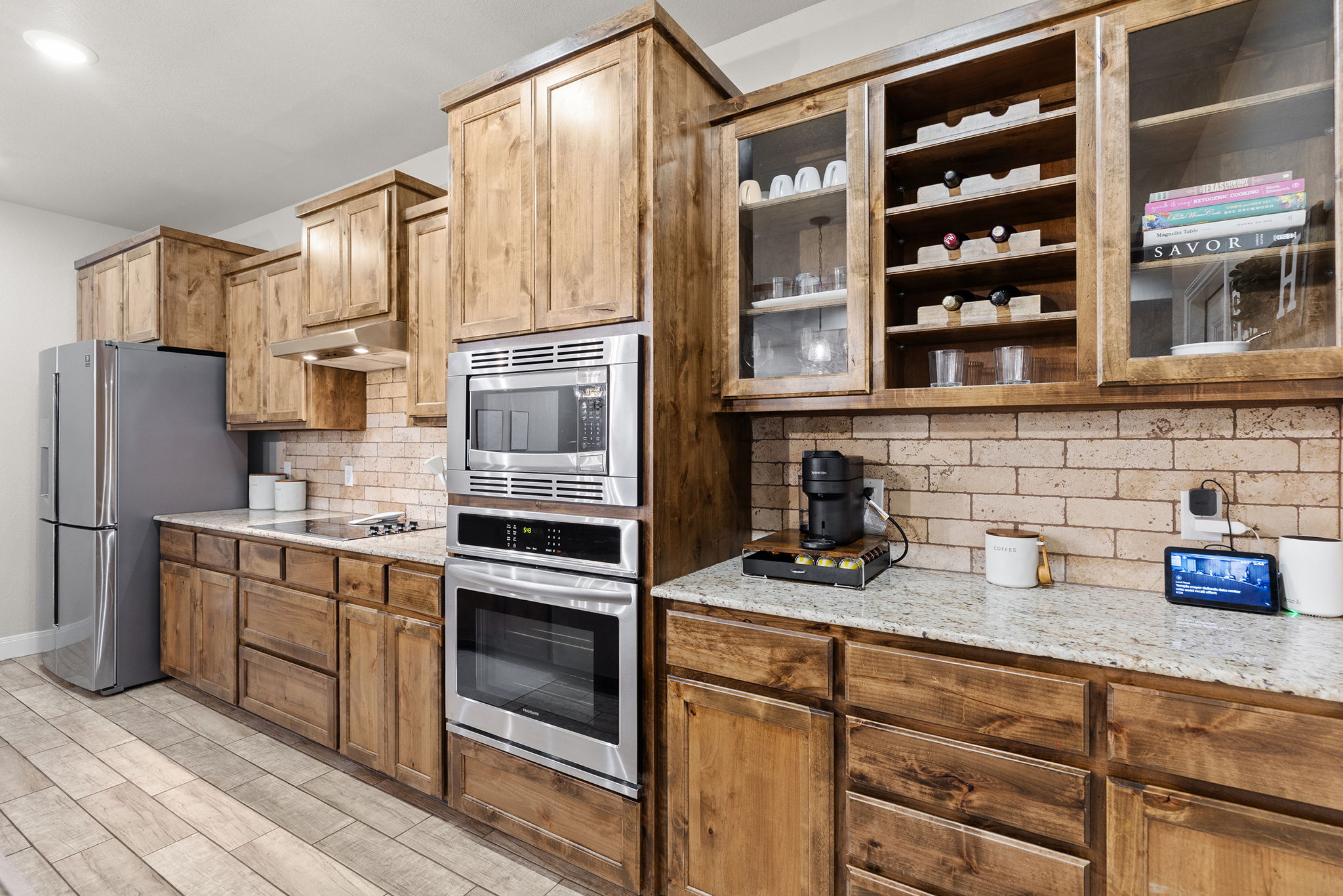 161 Greg Lane Jarrell, TX 76537 - Photo 11 of 35 Gourmet kitchen featuring wood cabinetry, stainless steel appliances, a built-in wine rack, and stone countertops
