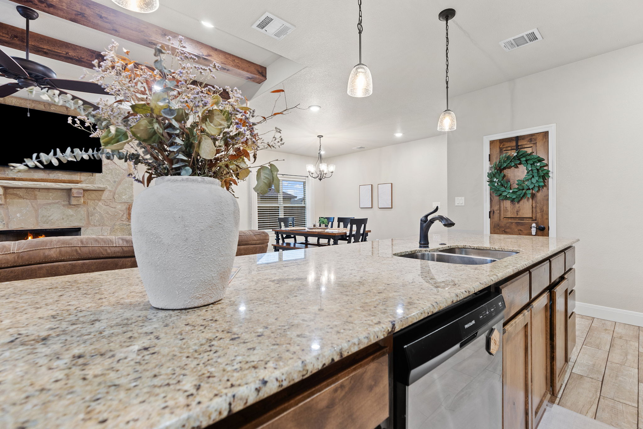 161 Greg Lane Jarrell, TX 76537 - Photo 13 of 35 Kitchen island featuring a stainless steel sink with a matte black faucet, granite countertops, and integrated dishwasher