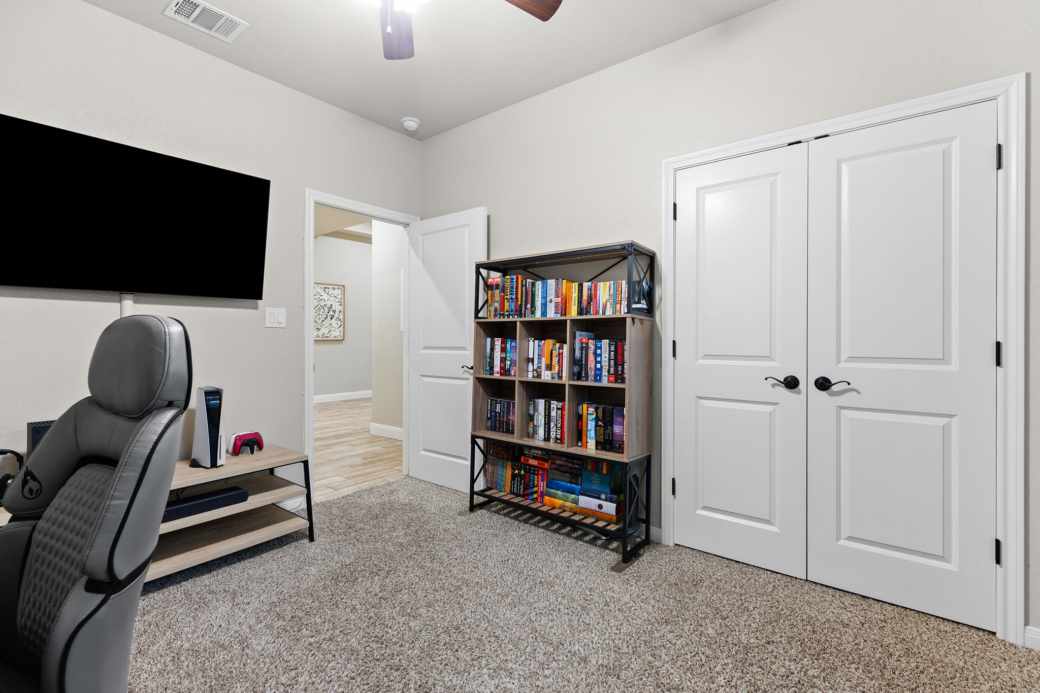 161 Greg Lane Jarrell, TX 76537 - Photo 24 of 35 Carpeted room featuring a ceiling fan, dual white panel doors, and a wall-mounted television